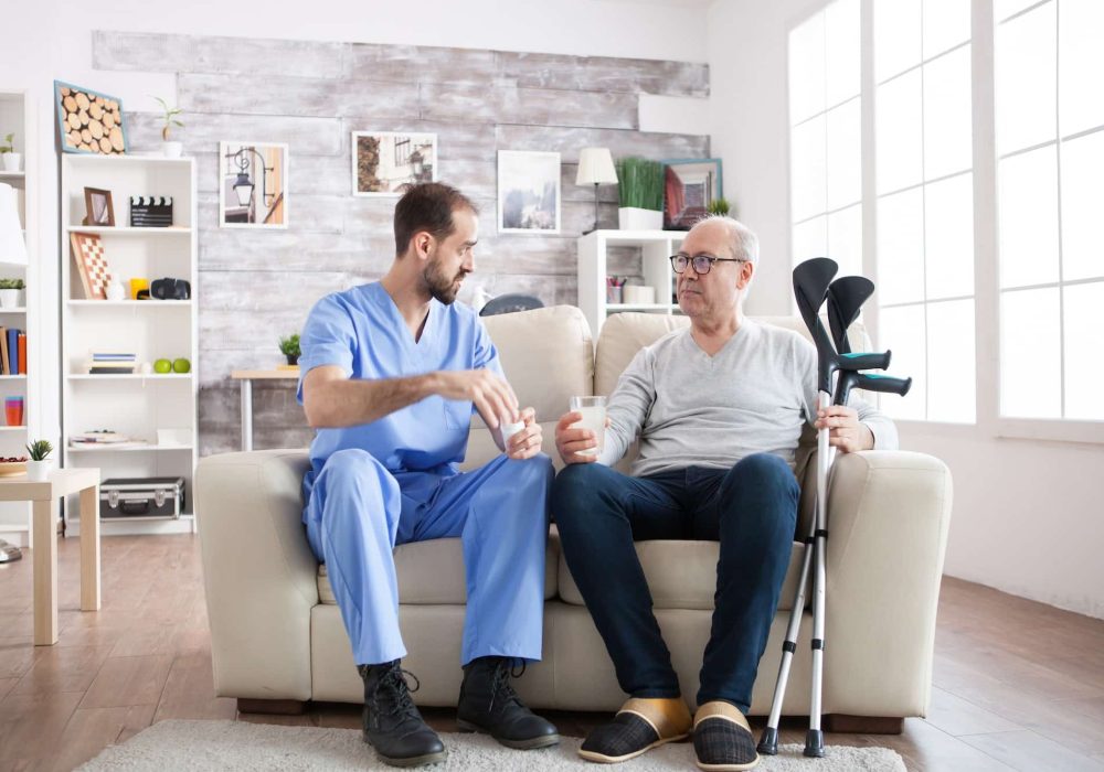 young-male-nurse-in-nursing-home-with-pills-for-senior-man.jpg